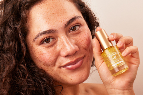 A woman holding a bottle of vitamin c serum