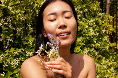 A woman holding flowers close to her face