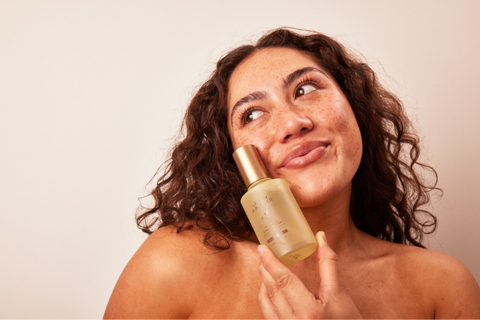 A woman with a bottle of Lemon & Beaker foaming cleanser