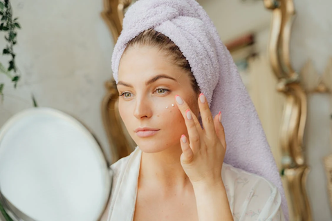 A woman applying cream to her face