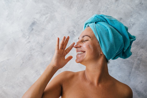 A woman putting moisturizer on her face 